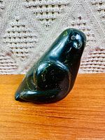 Left profile of the polished dark green stone bird