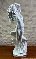 Full front view of white stoneware Aphrodite sculpture on wooden surface