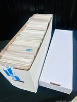 Long comic box filled with bagged comics next to empty box