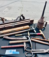 Overview of all tools laid out: planes, levels, pulley, oil can, hammers