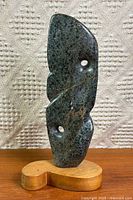 Full view of marble sculpture on wooden base