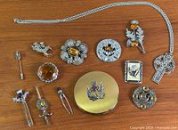All thirteen Scottish themed jewelry pieces laid out on wood background