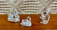 All three Swarovski crystal figurines side by side on wood surface