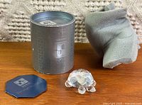 Figurine with cylindrical box, foam insert and hexagonal booklet