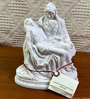 Front view of white cast marble Pietà statue showing detail and certificate tag