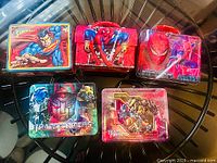 Group shot of five lunch boxes showing fronts and handles