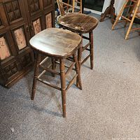 Two wooden bar stools in room setting