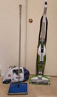 Three cleaning appliances standing upright