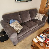 Front view of gray three-cushion sofa with two accent pillows