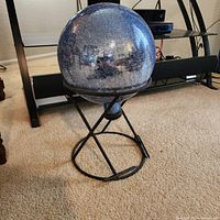 crackle glass globe seated in metal stand, full view