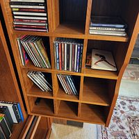 CDs in cubby shelves, various titles visible