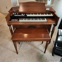 Front view of Hammond M3 organ and bench showing manuals and pedals
