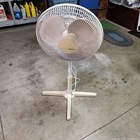 Front view of Holmes pedestal fan showing grille, blades, pole, base