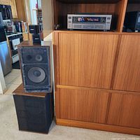 JVC receiver in cabinet, Pioneer speaker pair with one grille removed, Bose bookshelf speaker on top