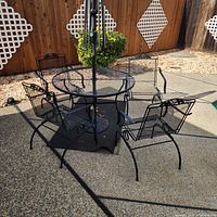 Complete patio set showing table, four chairs, umbrella pole, stand, mat