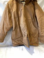 Front view of brown hooded canvas jacket showing pockets and closure