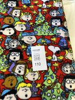 Folded fleece fabric showing Peanuts Christmas print with MaxSold tag