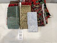 All seven folded pieces of Christmas fabric displayed on table