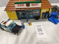Front exterior of assembled Kwik-E-Mart, police car and minifigures visible