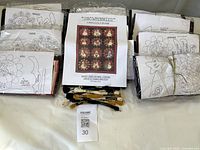 Overall view of Snowpennies Block of the Month kit with packaged monthly patterns, fleece pieces and embroidery floss