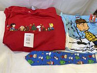 Lot overview showing red Christmas T-shirt, blue boxer shorts with tag, and blue Peanuts necktie