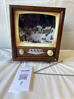 Front view of retro TV Christmas display showing village scene and detached antenna