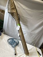 rod case and landing net on table