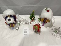 Group shot of two Whoville houses, Grinch figurine, ornament and cords