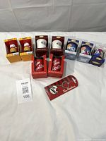 all nine ornaments and keychain laid out in boxes and packaging