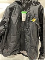 Full front view of black Bass Pro Shops raincoat with hood, pockets, logo