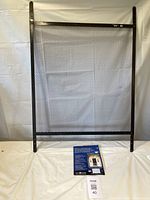 Full view of brown steel door grille standing upright with instruction sheet below