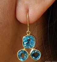 Earring worn on ear showing scale and stone arrangement
