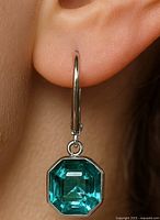 Earring worn on ear showing drop style and stone cut