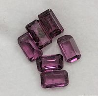 Close-up of six rectangular garnets showing color and cut