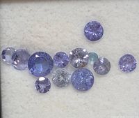 Close-up of loose round violet-blue tanzanite stones on white foam