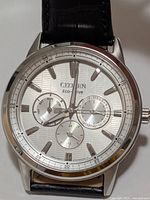 Front view showing dial, subdials, applied indices, Eco-Drive branding