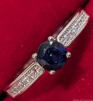 Front view showing sapphire-color center stone and CZ shoulders