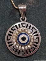 Front view of the silver evil eye pendant showing design details