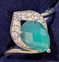 Front view of sterling silver ring featuring pear-shaped green onyx and surrounding cubic zirconia
