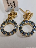 Front view of sapphire circle earrings with weight tag visible