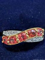 Crossover silver ring with orange sapphires and clear accents