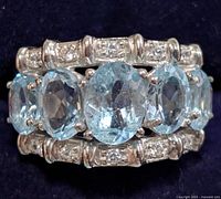 Front view of silver ring with blue topaz and accent stones