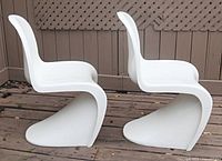 Side view of both white Panton-style chairs showing S-curve profile