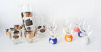 Pitcher, six lowball glasses, eight novelty base shot glasses grouped