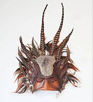 Front view showing full mask with feathers and fur
