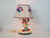 Full view of clown lamp lit showing shade and base