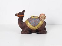 Left side view of camel figurine showing painted saddle and vase opening