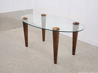 Full view of oval glass coffee table showing legs and top