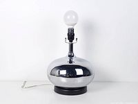 Full view of chrome ball table lamp with bulb for scale