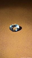 Oval faceted aquamarine front view on surface